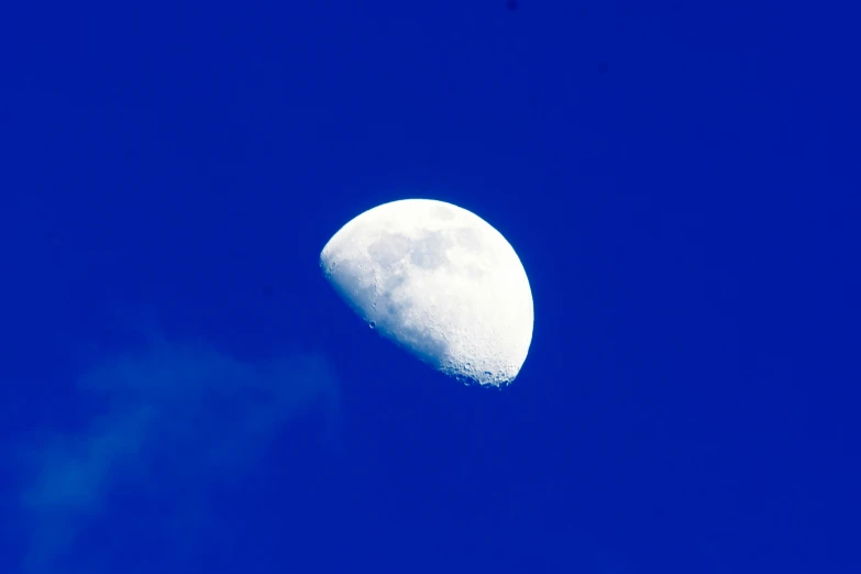 the moon is almost almost white in the blue sky