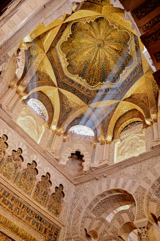 inside an ornate building with paintings on the walls