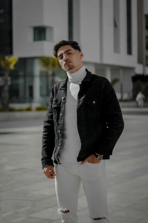 a young man standing outside in front of a large building