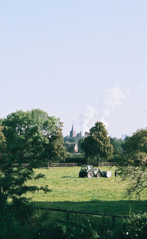 a tractor sitting in the middle of a grassy field