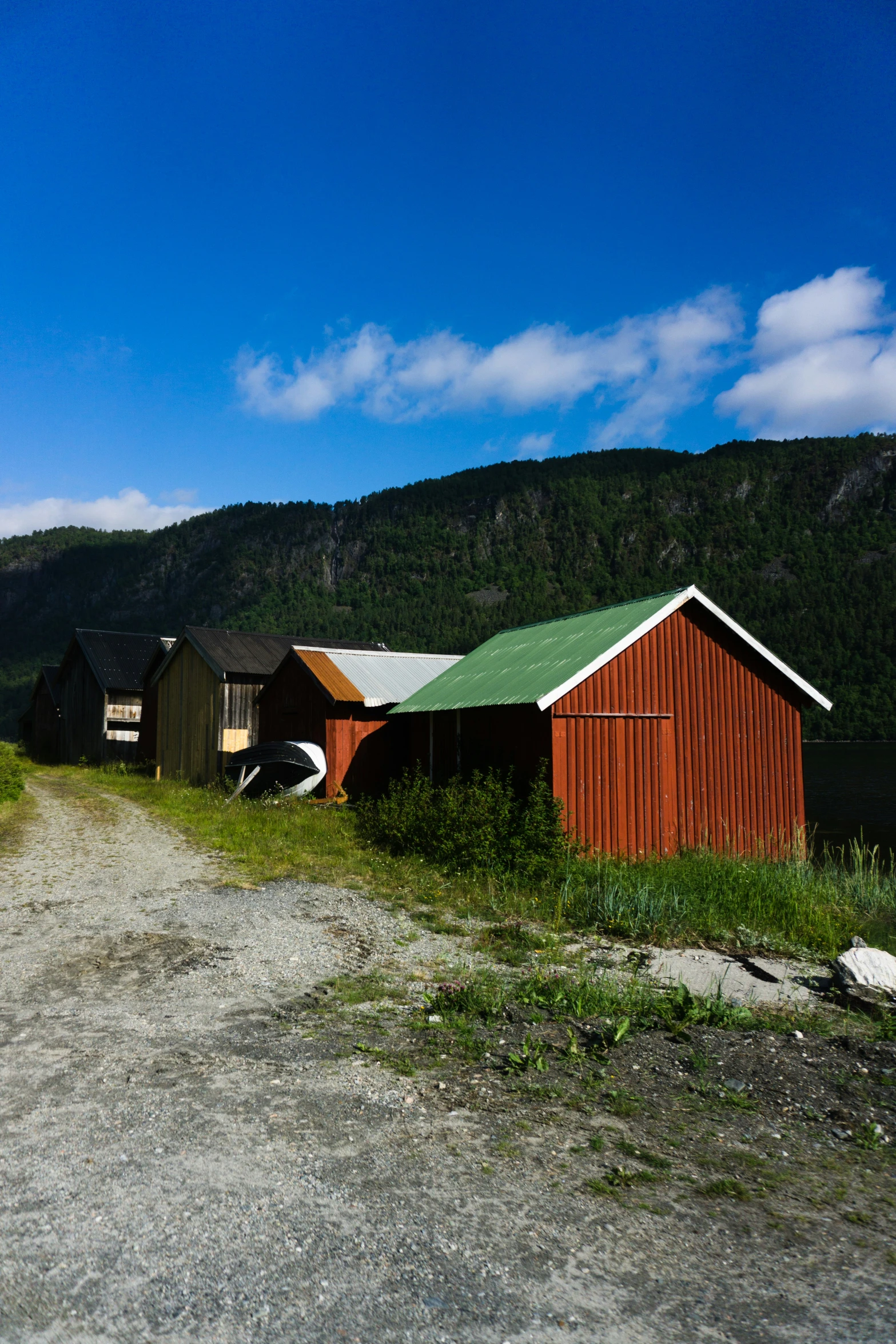 two barns sitting on a farm near a mountain