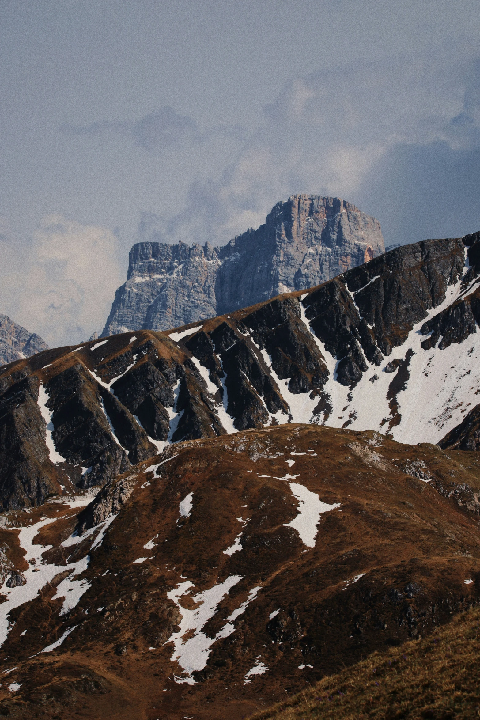 a mountain covered in snow and brown grass