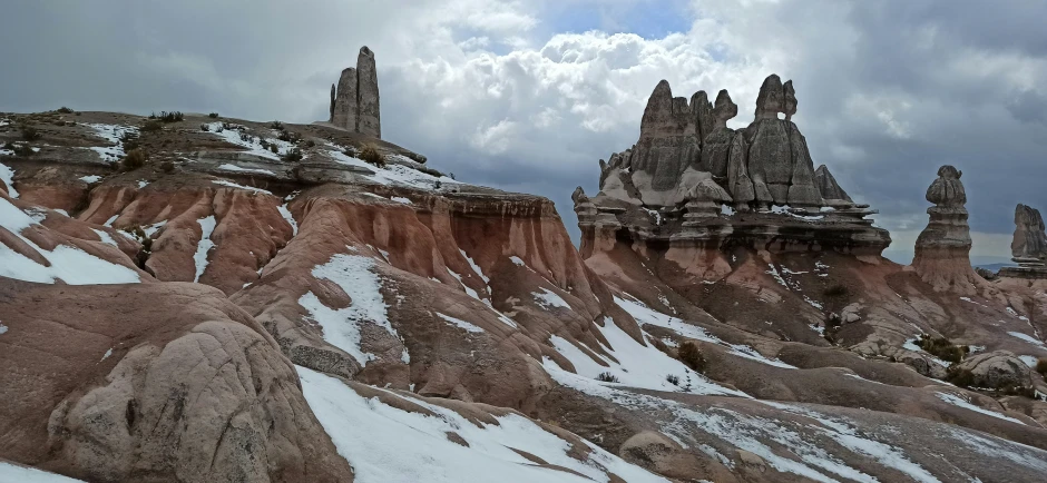 some very large rocks and some snow on a mountain