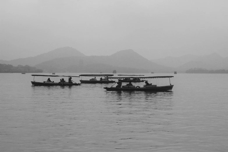 several small boats floating in the middle of a lake