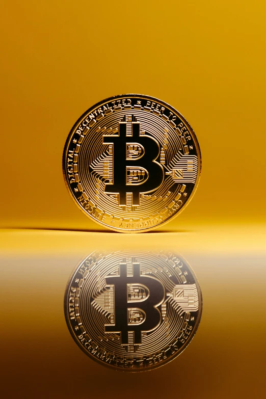 a bitcoin coin is reflected on the shiny surface