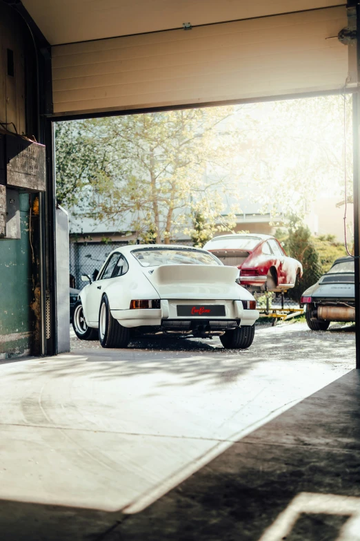 a car parked inside of a garage with fire trucks nearby