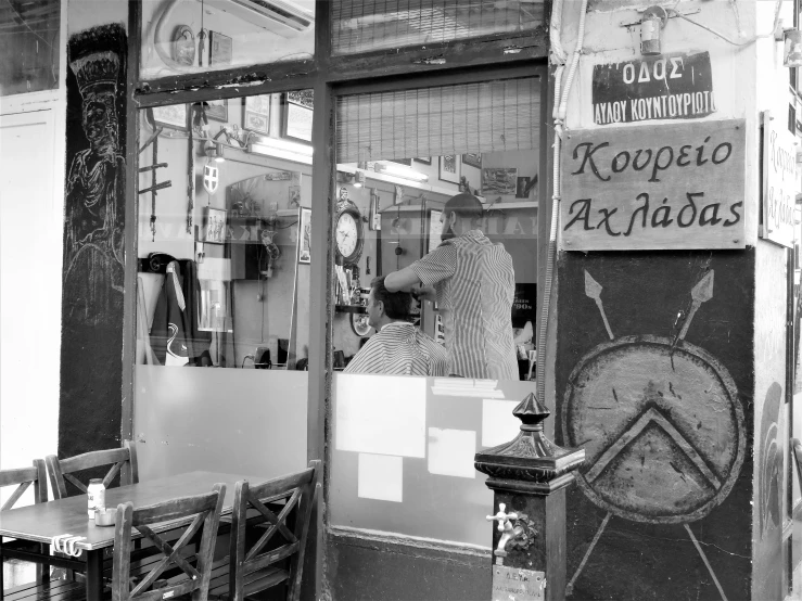 an old fashion store with the reflection of another man at its window