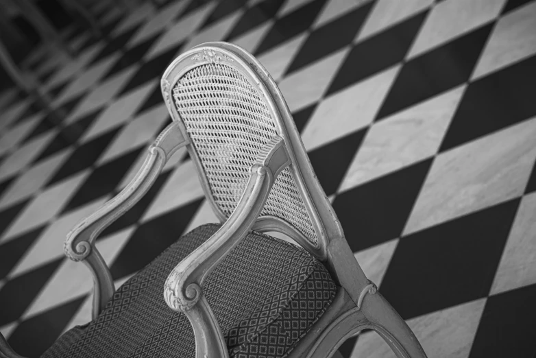 a black and white po of a chair on a checkered floor