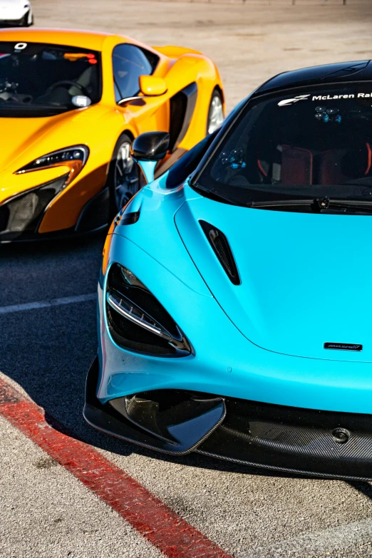 two sport cars driving through the street near each other