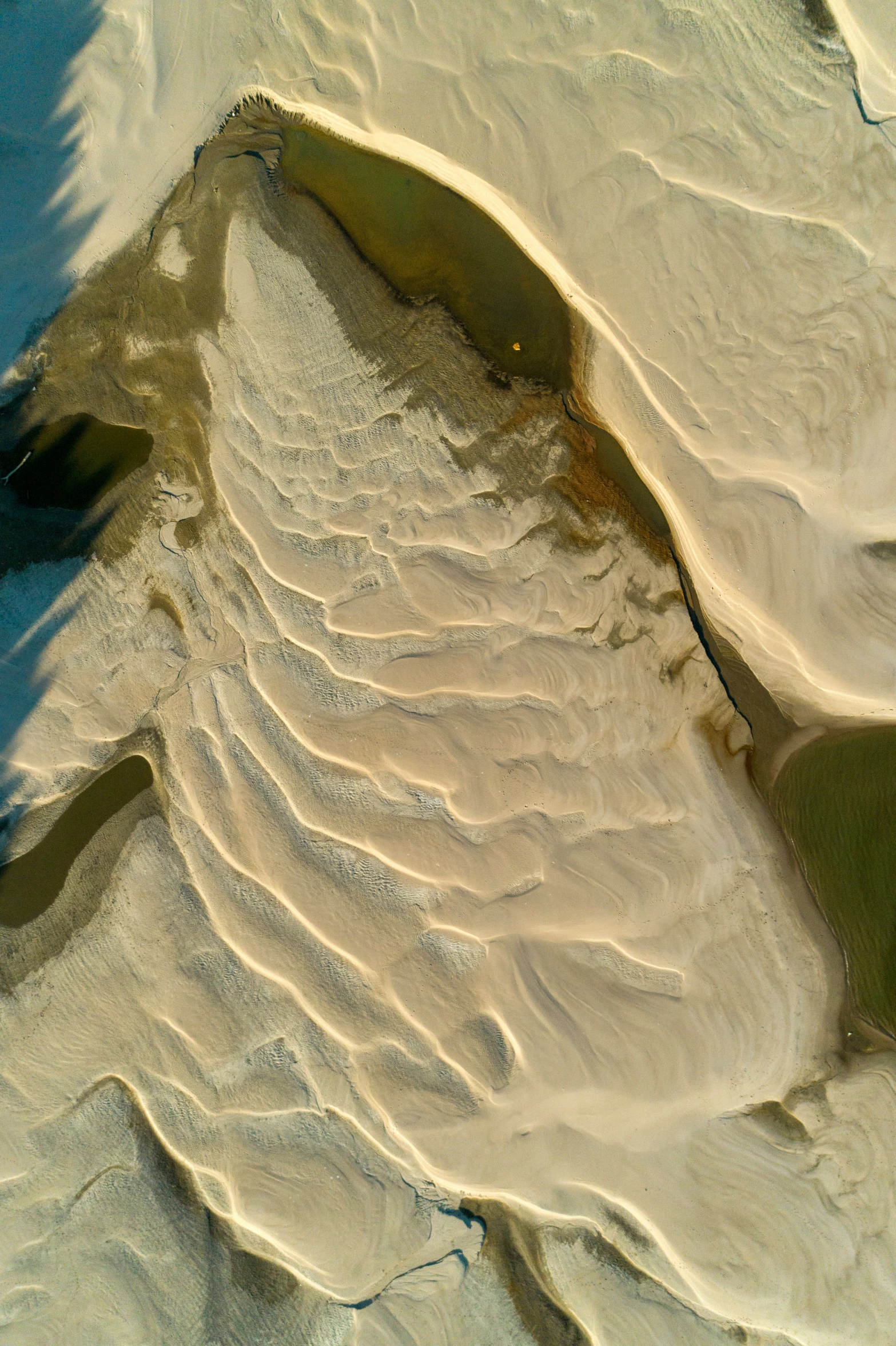 a barren area surrounded by sand and water