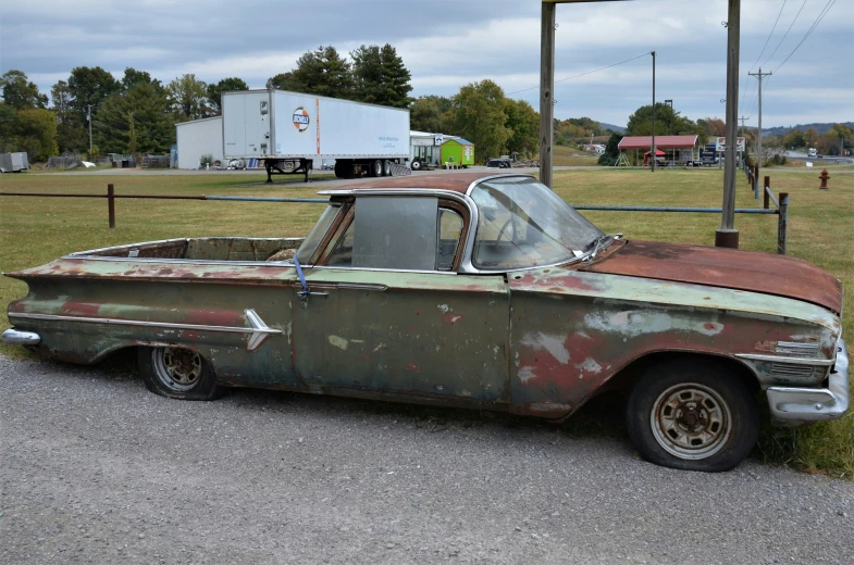 an old truck with rusty paint sits in the middle of a field