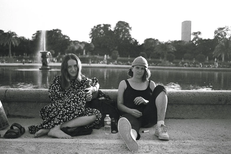 a black and white po of two women sitting on a skateboard