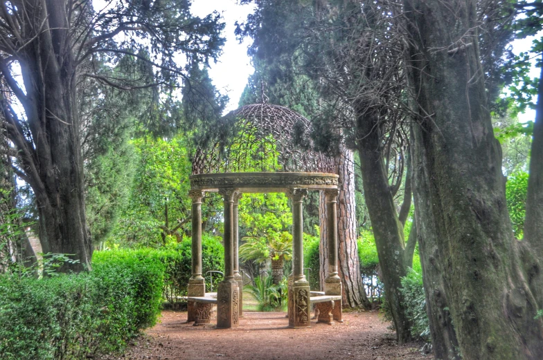 a wooden gazebo and benches near trees