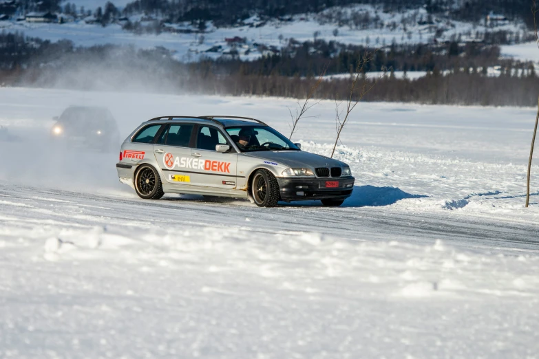 a white bmw in the snow by a person