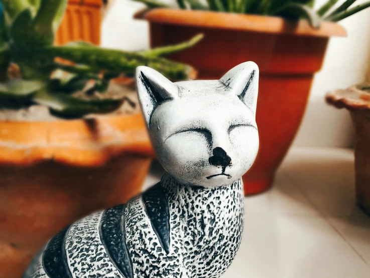 there is a figurine of a cat wearing a vest and plants