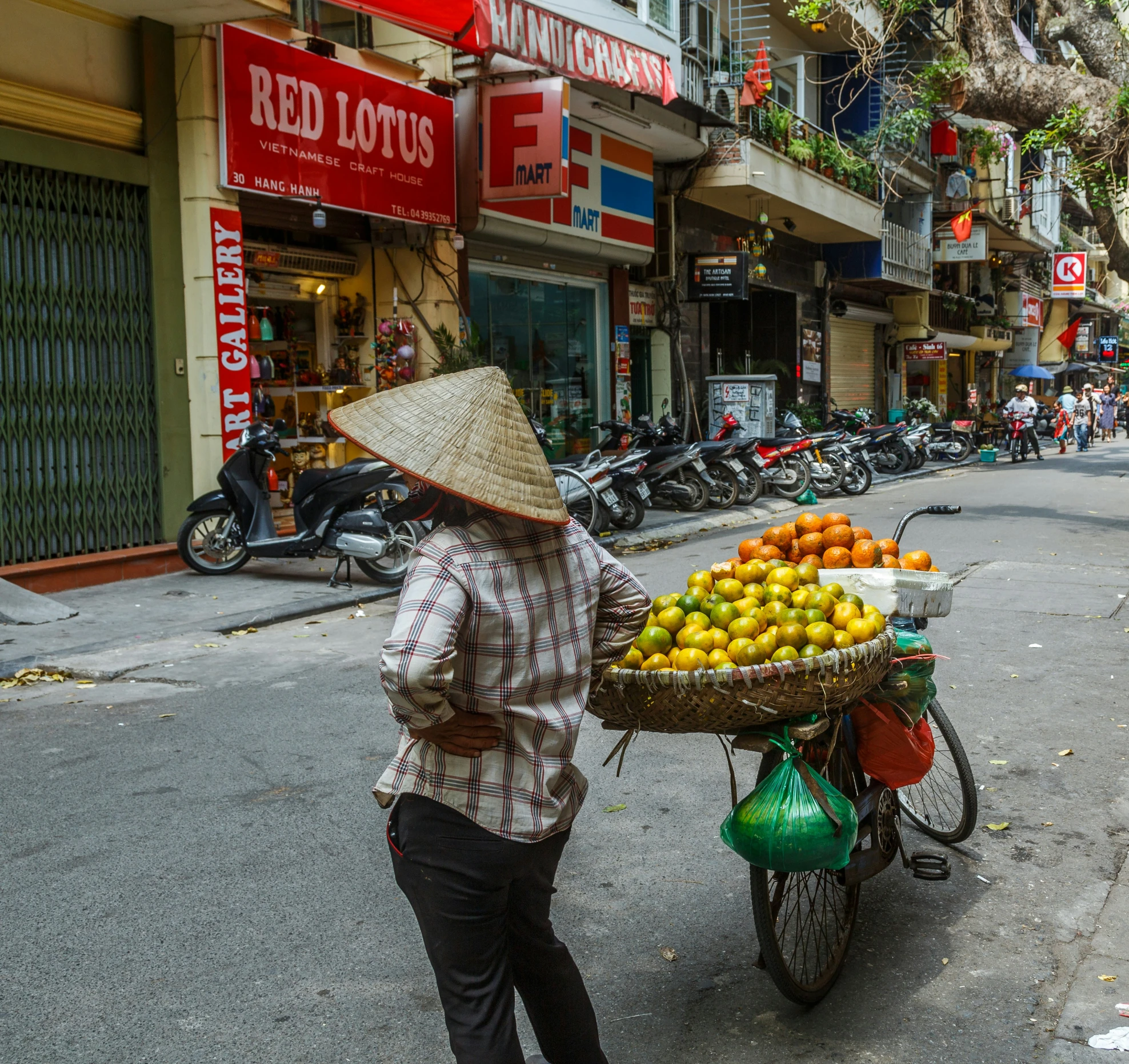 a woman hing a cart with fruit on it