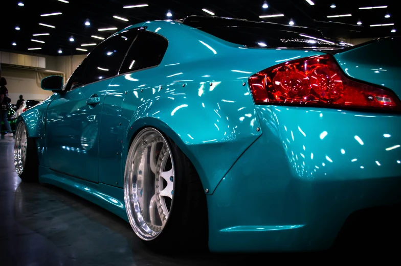 the back of a blue car with chrome wheels