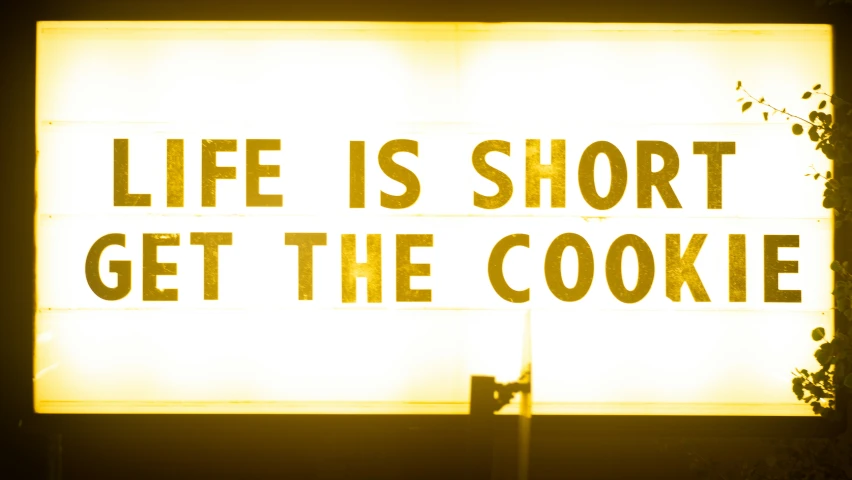 there is a light sign that reads life is short get the cookie