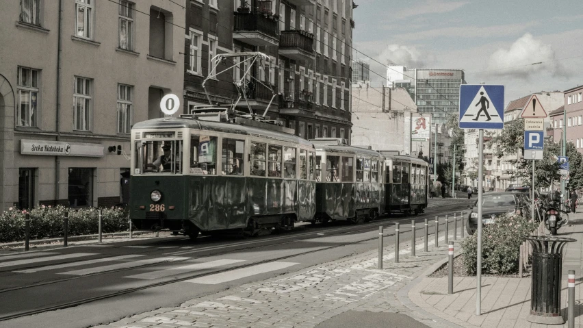 the trolly rides down the street on a cloudy day