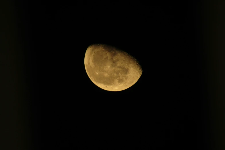 the moon is seen in the dark black night sky