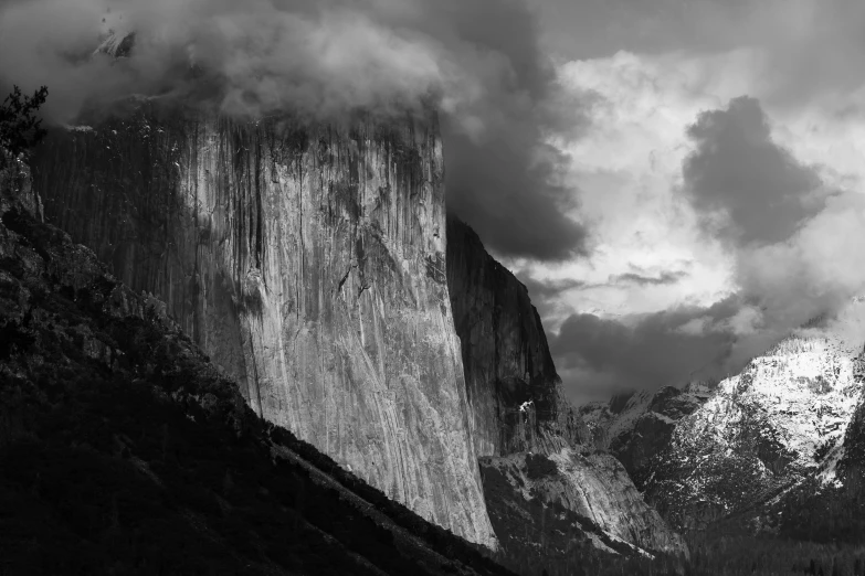 a view of a mountain with a steep face and clouds