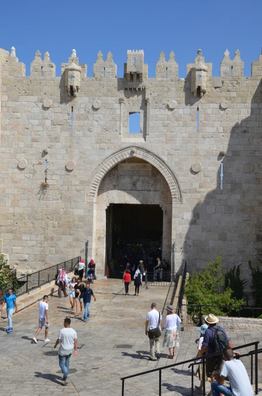 people are walking and walking around in a walkway next to a wall