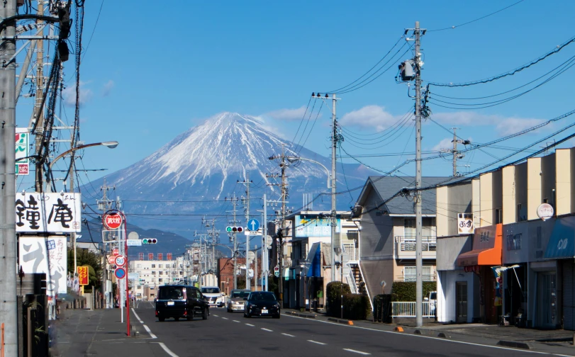 view down the road from a town with a snowy mountain in the background