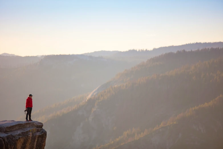 the man is standing on the edge of the cliff