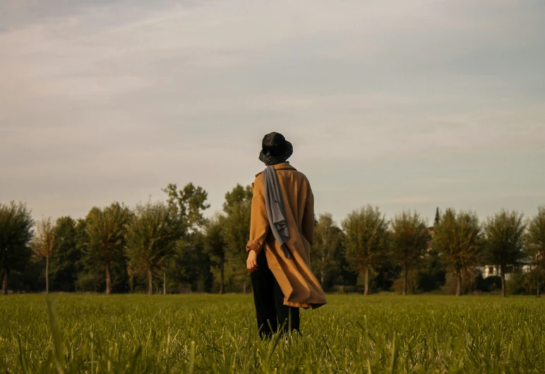 a woman standing in a field looking into the sky
