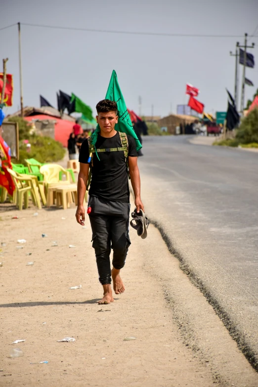 a man walking down the road with many chairs