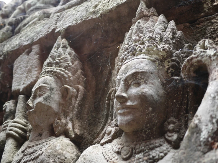 statues of women in the shape of heads are lined up on a wall