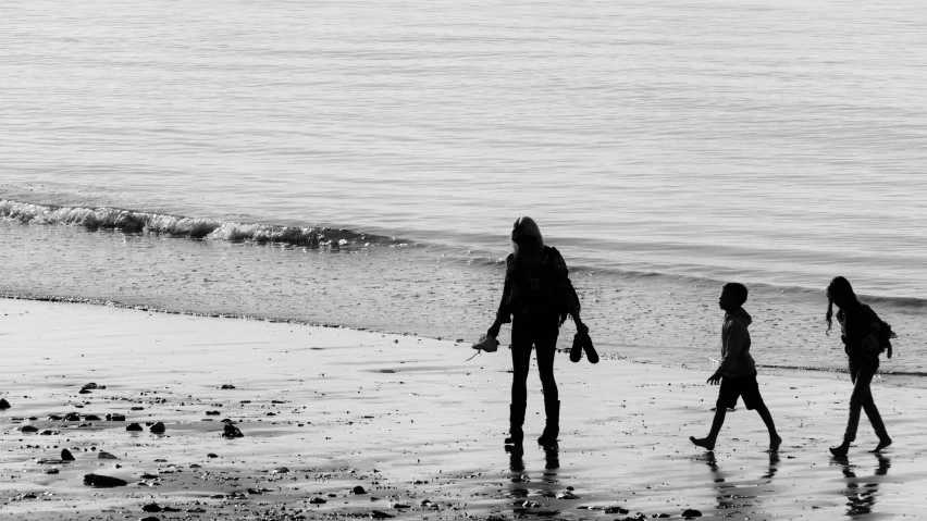 a family silhouetted on the beach by the ocean