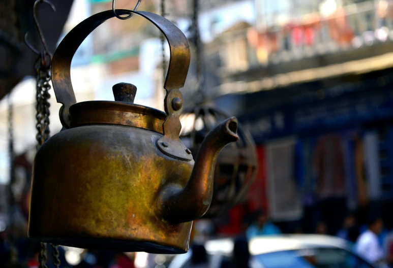 an antique teapot with one tea pot hanging on a chain