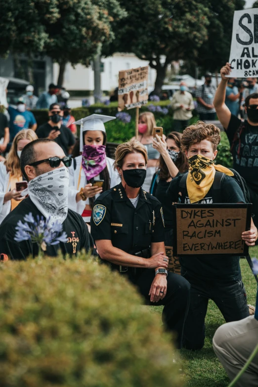 protesters wearing face masks holding up signs outside