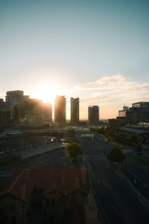 a beautiful sunset over some large buildings in the distance