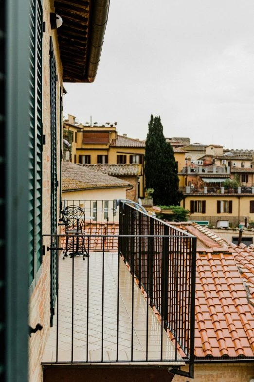 a view from a window of some buildings and red tile roofs