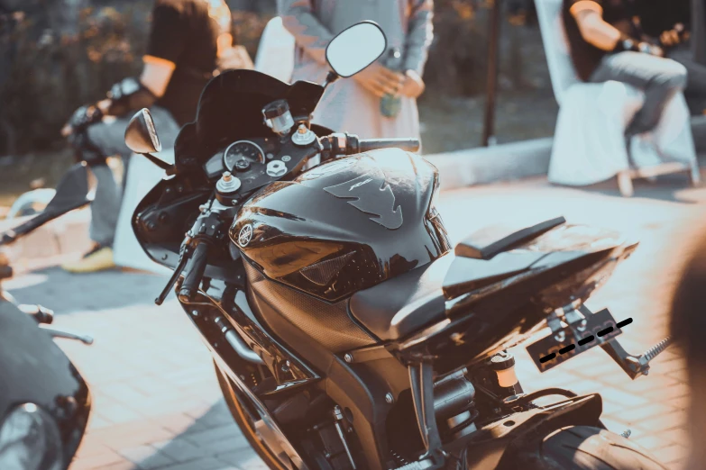 a motorcycle parked with people around and two women and a bride