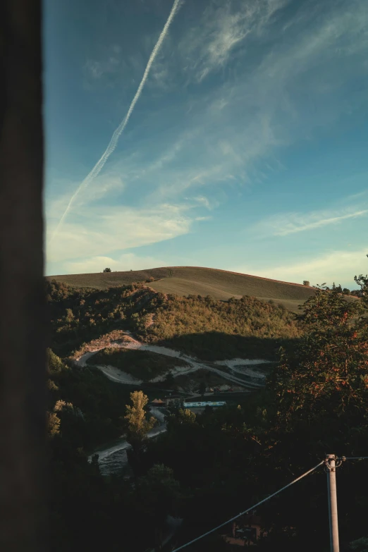 the view from the street is of some hills and trees