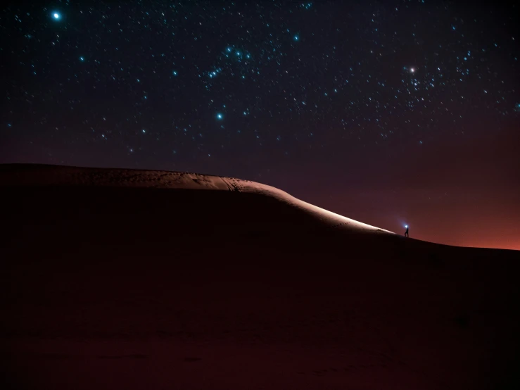 a desert area with some stars above it