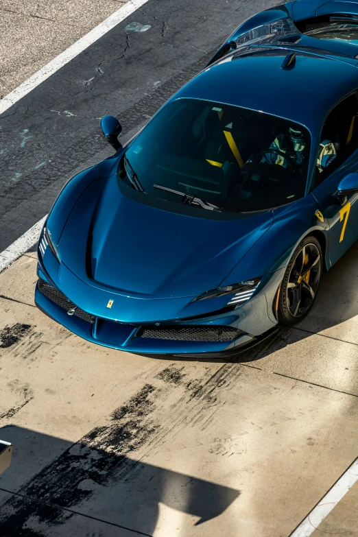 a blue car driving down a road next to a person