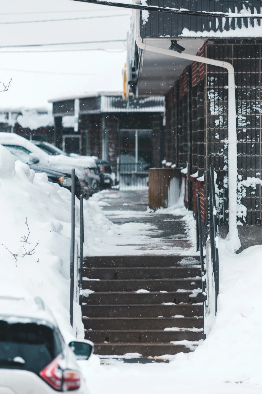 a street sign stands in the middle of a snowy sidewalk