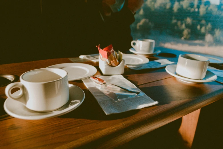 a table set with two cups and plates