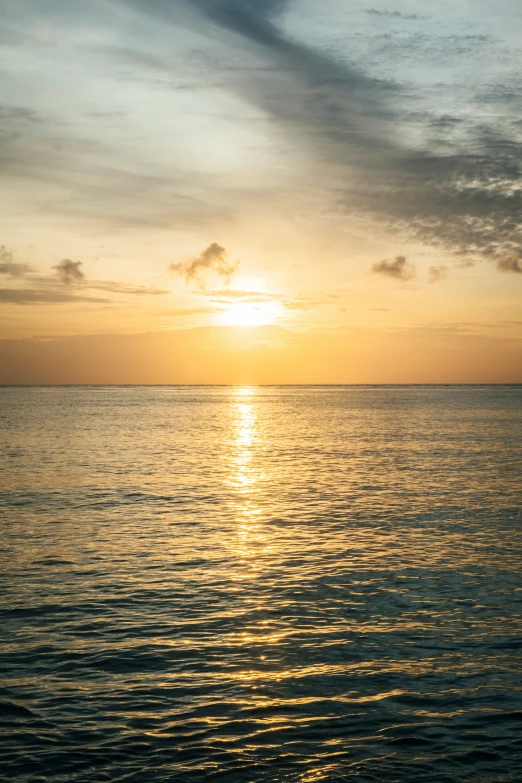 the sun is setting on the horizon as it reflects in the ocean