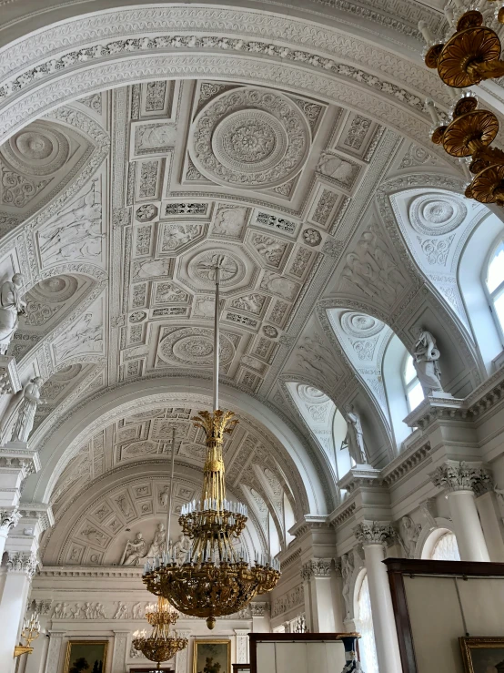 a white room with an elaborate ceiling and chandelier