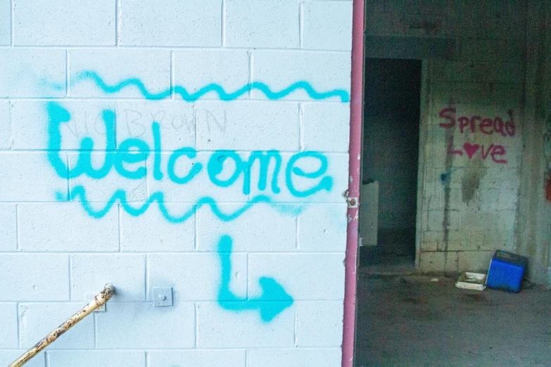 a welcome sign spray painted on the side of a building