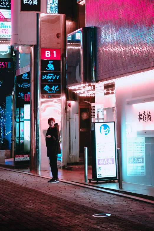 a person standing outside of a building at night