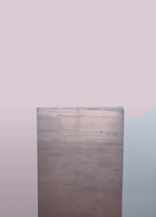 a piece of wooden sitting against a pale wall