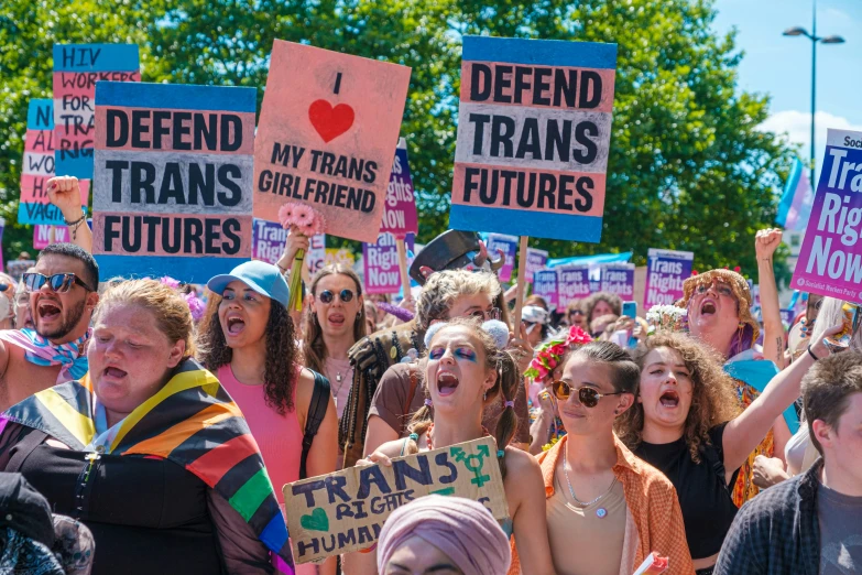 a large group of people holding up signs in a crowd