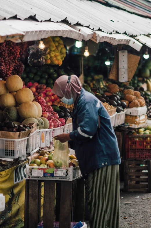 there is a person standing at the fruit stand