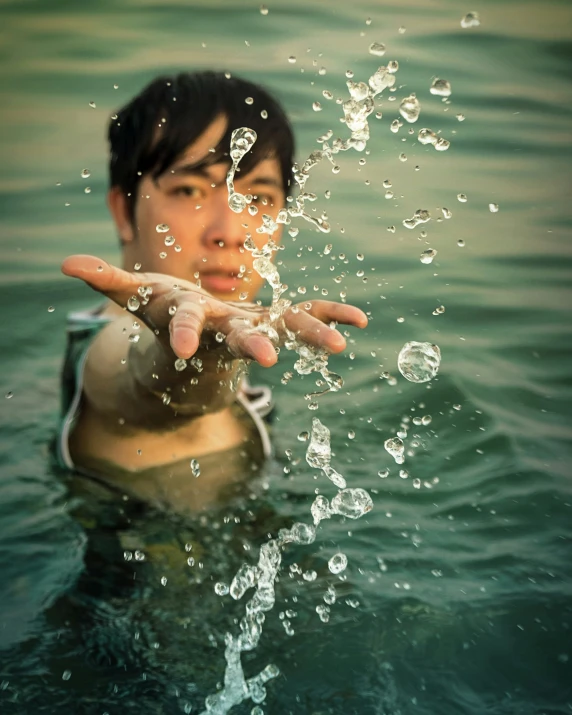 man holding up finger with drops of water all over his body